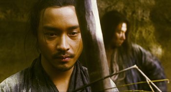 Movie still from “Ashes of Time” (1994), directed by Kar-Wai Wong – A man with a beard is looking at the camera; Close Up shot, Over the shoulder angle