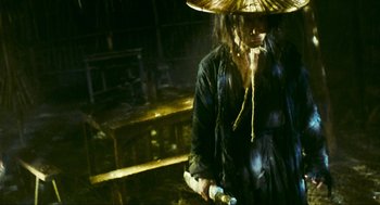 Movie still from “Ashes of Time” (1994), directed by Kar-Wai Wong – A person wearing a hat and holding something in their hand; Medium shot, Low angle