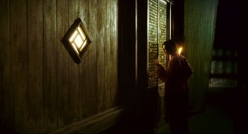 Movie still from “Ashes of Time” (1994), directed by Kar-Wai Wong – A person standing in front of a window with a light on; Wide shot, Low angle