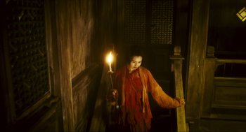 Movie still from “Ashes of Time” (1994), directed by Kar-Wai Wong – A woman holding a lit candle in a dark room; Medium shot, High angle