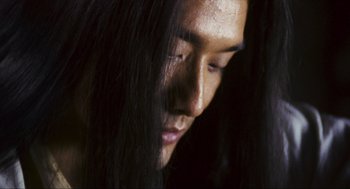 Movie still from “Ashes of Time” (1994), directed by Kar-Wai Wong – A person with long black hair; Close Up shot, Low angle