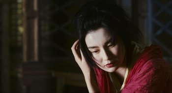 Movie still from “Ashes of Time” (1994), directed by Kar-Wai Wong – A woman in a red shirt is touching her hair; Close Up shot, Low angle