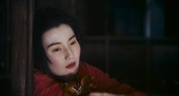 Movie still from “Ashes of Time” (1994), directed by Kar-Wai Wong – A woman in a red jacket holding a plant; Close Up shot, High angle