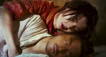 Movie still from “Ashes of Time” (1994), directed by Kar-Wai Wong – A man and a woman laying in a bed together; Close Up shot, Overhead angle