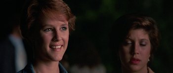 Movie still from “At Close Range” (1986), directed by James Foley – A person smiling; Close Up shot, Over the shoulder angle