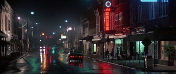 Movie still from “At Close Range” (1986), directed by James Foley – A car driving down a street at night; Wide shot, Low angle