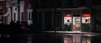 Movie still from “At Close Range” (1986), directed by James Foley – A street corner at night lit by street lights; Extreme Wide shot, High angle