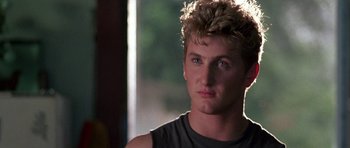 Movie still from “At Close Range” (1986), directed by James Foley – A person wearing a gray shirt; Close Up shot, Over the shoulder angle