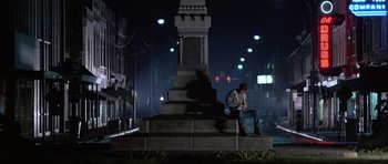 Movie still from “At Close Range” (1986), directed by James Foley – A man sitting on the side of the road at night; Wide shot, Low angle
