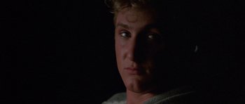 Movie still from “At Close Range” (1986), directed by James Foley – A man's face in the dark; Close Up shot, Over the shoulder angle