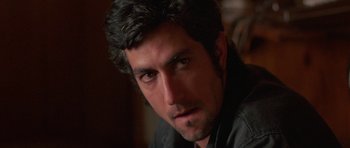 Movie still from “At Close Range” (1986), directed by James Foley – A person wearing a black shirt; Close Up shot, Over the shoulder angle