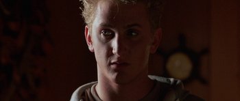 Movie still from “At Close Range” (1986), directed by James Foley – A young man with green eyes; Close Up shot, Low angle