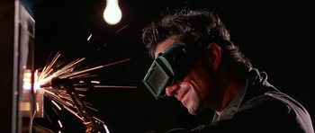 Movie still from “At Close Range” (1986), directed by James Foley – A man wearing a pair of welding goggles; Close Up shot, Low angle