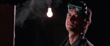 Movie still from “At Close Range” (1986), directed by James Foley – A person wearing goggles with smoke coming out of a light bulb; Close Up shot, Low angle