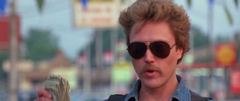 Movie still from “At Close Range” (1986), directed by James Foley – A person wearing sunglasses; Close Up shot, Low angle