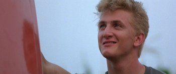 Movie still from “At Close Range” (1986), directed by James Foley – A person smiling; Close Up shot, Low angle