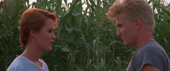 Movie still from “At Close Range” (1986), directed by James Foley – A man and a woman are talking in a field; Close Up shot, Over the shoulder angle