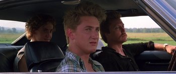 Movie still from “At Close Range” (1986), directed by James Foley – A man sitting in the back seat of a car; Close Up shot, Low angle
