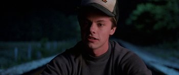 Movie still from “At Close Range” (1986), directed by James Foley – A young man wearing a baseball cap and a gray shirt; Close Up shot, Low angle