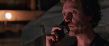 Movie still from “At Close Range” (1986), directed by James Foley – A person talking on a cell phone; Close Up shot, Low angle