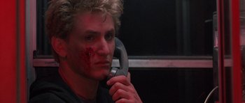 Movie still from “At Close Range” (1986), directed by James Foley – A young man holding a pair of wrenches with blood on his face; Close Up shot, Low angle