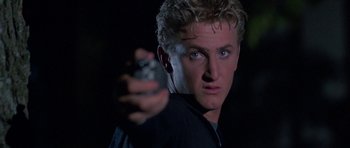 Movie still from “At Close Range” (1986), directed by James Foley – A person holding a cell phone; Close Up shot, Low angle