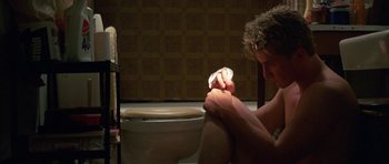 Movie still from “At Close Range” (1986), directed by James Foley – A man sitting on a toilet in a bathroom; Close Up shot, High angle