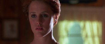 Movie still from “At Close Range” (1986), directed by James Foley – A woman's face in a room; Close Up shot, Low angle