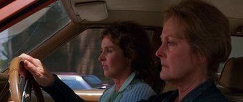 Movie still from “At Close Range” (1986), directed by James Foley – Two women sitting in the back seat of a car; Close Up shot, Over the shoulder angle