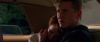 Movie still from “At Close Range” (1986), directed by James Foley – A man and a woman sitting in the back seat of a car; Close Up shot, Low angle