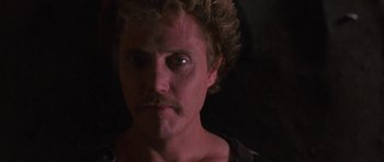 Movie still from “At Close Range” (1986), directed by James Foley – A person with a beard and a mustache; Close Up shot, Over the shoulder angle