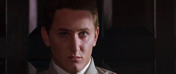 Movie still from “At Close Range” (1986), directed by James Foley – A person wearing a suit and tie; Close Up shot, Low angle