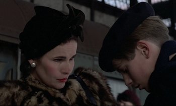 Movie still from “Au revoir les enfants” (1987), directed by Louis Malle – A woman and a man wearing hats and fur; Close Up shot, Over the shoulder angle