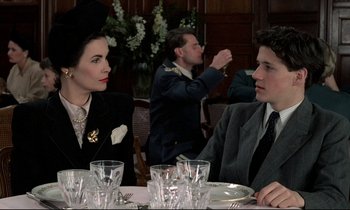 Movie still from “Au revoir les enfants” (1987), directed by Louis Malle – A man and a woman sitting at a dinner table; Medium shot, Over the shoulder angle