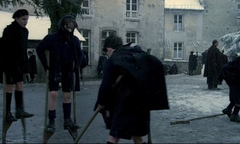 Movie still from “Au revoir les enfants” (1987), directed by Louis Malle – Two young boys are walking in the rain; Wide shot, High angle