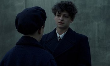 Movie still from “Au revoir les enfants” (1987), directed by Louis Malle – A man in a suit and tie talking to another man in a suit and tie; Close Up shot, Over the shoulder angle