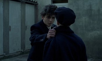 Movie still from “Au revoir les enfants” (1987), directed by Louis Malle – A young man is looking at his reflection in a mirror; Close Up shot, Over the shoulder angle