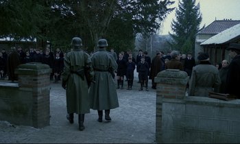 Movie still from “Au revoir les enfants” (1987), directed by Louis Malle – A group of men in uniforms and hats standing next to each other; Wide shot, High angle