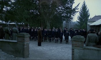 Movie still from “Au revoir les enfants” (1987), directed by Louis Malle – A large group of people standing in the middle of a field; Extreme Wide shot, High angle