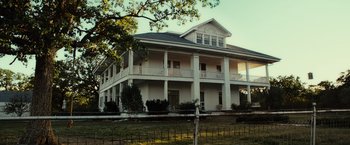 Movie still from “August: Osage County” (2013), directed by John Wells – A large white two - story house sitting on top of a field; Extreme Wide shot, Low angle