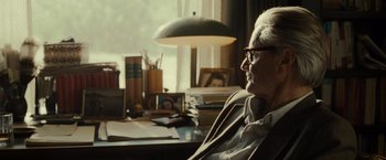 Movie still from “August: Osage County” (2013), directed by John Wells – An older man sitting at a desk in front of a window; Close Up shot, Over the shoulder angle