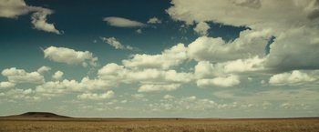 Movie still from “August: Osage County” (2013), directed by John Wells – A large open field under a blue sky with some clouds; Extreme Wide shot, Low angle