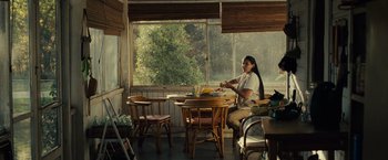 Movie still from “August: Osage County” (2013), directed by John Wells – A woman sitting at a table in front of a window; Wide shot, Over the shoulder angle