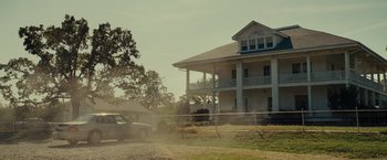 Movie still from “August: Osage County” (2013), directed by John Wells – A car is parked in front of a large house; Extreme Wide shot, Low angle
