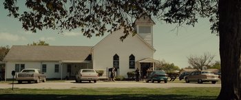Movie still from “August: Osage County” (2013), directed by John Wells – A white church with people standing in front of it; Extreme Wide shot, Low angle