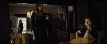 Movie still from “August: Osage County” (2013), directed by John Wells – A woman standing in front of a man in a living room; Medium shot, Over the shoulder angle