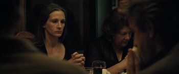 Movie still from “August: Osage County” (2013), directed by John Wells – Two women sitting at a dinner table holding their hands together; Close Up shot, Over the shoulder angle