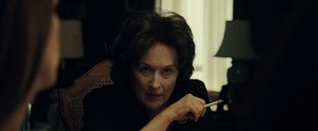 Movie still from “August: Osage County” (2013), directed by John Wells – An older woman is holding a cigarette in her mouth; Close Up shot, Over the shoulder angle