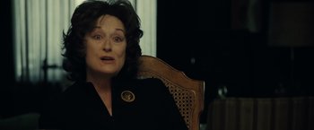 Movie still from “August: Osage County” (2013), directed by John Wells – An older woman sitting in a chair with her eyes wide open; Close Up shot, Over the shoulder angle