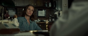 Movie still from “August: Osage County” (2013), directed by John Wells – A woman sitting at a table in front of a brick wall; Close Up shot, Over the shoulder angle